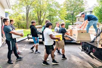 The West Milford High School football team helps move books for the Wallisch Homestead annual book sale last weekend.