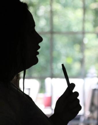 Silhouette of teen holding vaping device.