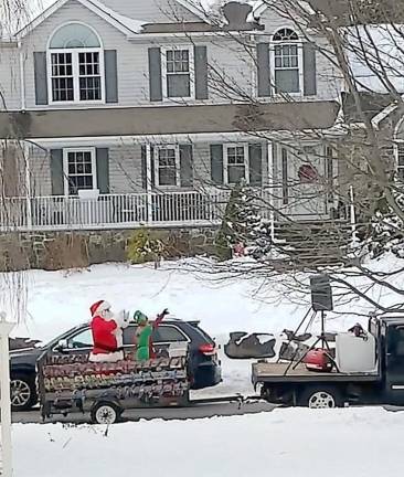 Santa and his Elf danced around to holiday tunes and waved to families as they toured the township in a trailer. Photo by Patricia Keller.
