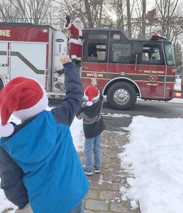 Alexander and James Fulton wave to Santa and WMFD Company 6 firefighters. Their mother, Jennifer Fulton, said: We are so thankful that company six was able to come around this year! My boys were ecstatic to see Santa! Photo submitted by Jennifer Fulton.