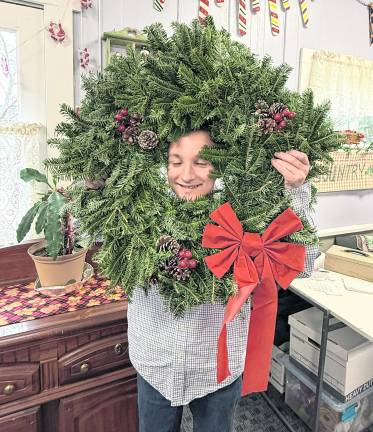 Riley Brand of West Milford Boy Scout Troop 44 looks through a wreath.