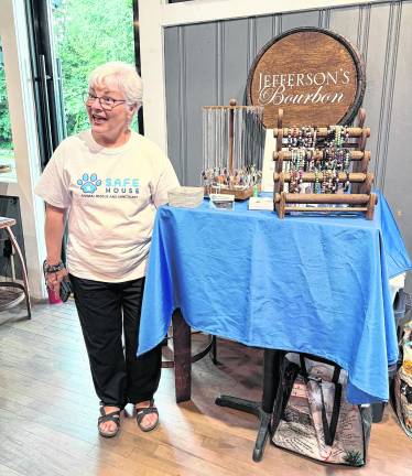 Nancy O’Tool from S.A.F.E. House animal rescue and sanctuary offers jewelry she makes for sale as part of the fundraiser.