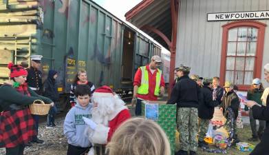 Santa talks to children at the Newfoundland Train Station while volunteers load donated toys on the train. (Photos by Kathy Shwiff)