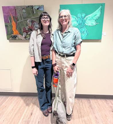 Ella Zimmer and her mother pose in front of artwork.