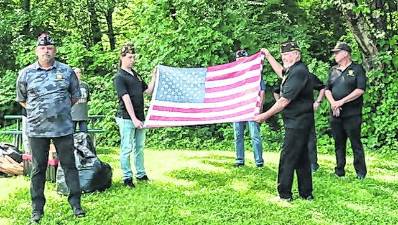 The West Milford Veterans of Foreign Wars hold an American flag.