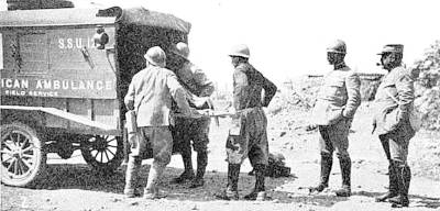 Men load a stretcher into an ambulance during World War 1, taken in the Reims-Verdon sector of France, 1918.