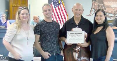 Jimmy “The Barber” Thurstan holds up his certificate of recognition at a recent township council meeting.