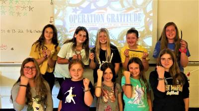 Maple Road Youthact Club students display their wristbands to honor the U.S. military.