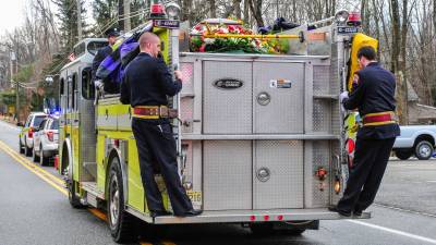 Photos by Mark Cranston The casket carrying the body of longtime firefighter Adrian Birdsall is atop Fire Company 6 engine on its way to Cedar Heights Cemetery.