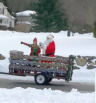 Santa had company - one of his Elves tagged along as Cub Scout Pack 9 drove them around the Macopin/Old Milford Estates area in a trailer. Photo by Patricia Keller.