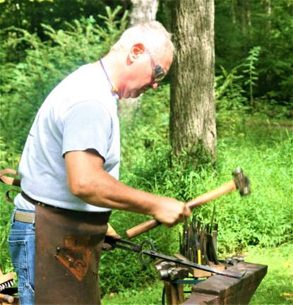 [Wyckoff Blacksmith Gaspar Lesznik conducts a field demonstration of 19th century metal work at the Long Pond Ironworks State Park in Hewitt on Saturday. Charles Kim photo]