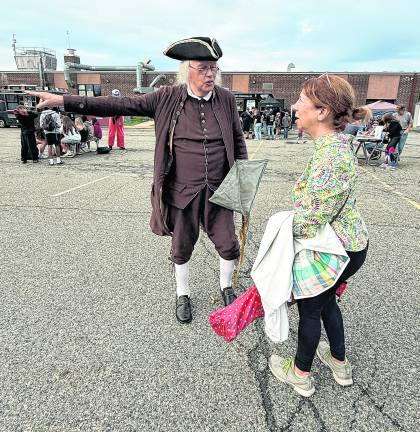 An actor dressed as Benjamin Franklin gives directions.