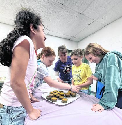 From left, Gabi Gonzalez, 10, Brooke Prosper, 9, Marjorie Yacco, Abby Scully, 10, and Ella Weidmuller, 9, frost cupcakes.