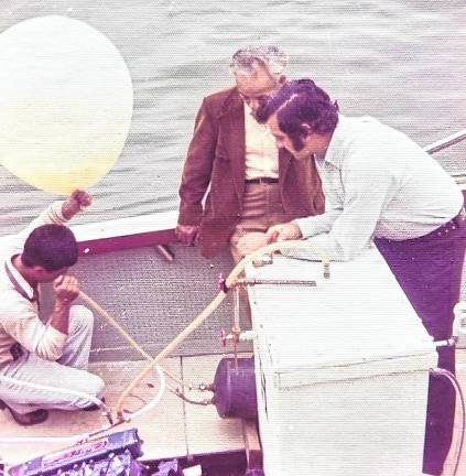 Inventor Francisco Pacheco, seated at the edge of the boat, directs his grandson Edwardo, as he operates a 26-foot vessel with hydrogen power for nine hours in a 1974 Point Pleasant demonstration.