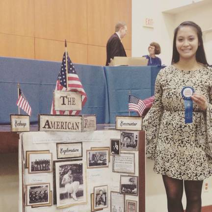 Andrea Hilario is shown here with her American Flapper exhibit, for which she won a blue ribbon at the National History Day competition.