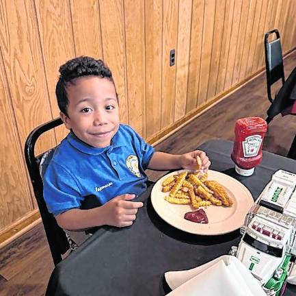 Jayeson Hayword, 7, an alternate ambassador, eats.