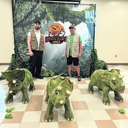 Ben Johnson and Mu Suriyalangka of Dinosaurs Alive stand behind three triceratops displays.