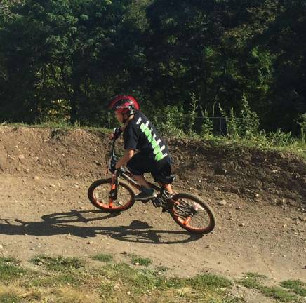 Joey, age 10, enjoys a ride on the pump track.