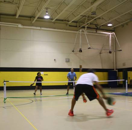 Dimas Marquez of Highland Mills, N.Y., goes after a shot from Silvia Feldman and Ben Scaturro.