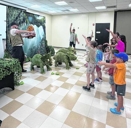 Ben Johnson and Mu Suriyalangka of Dinosaurs Alive lead the children in a dance.