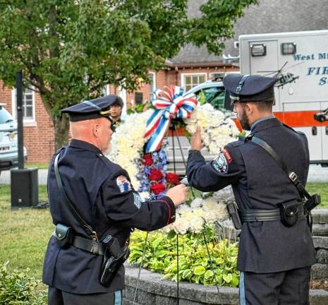 Police officers place a wreath near a memorial to West Milford residents killed in the Sept. 11, 2001, terrorist attacks.