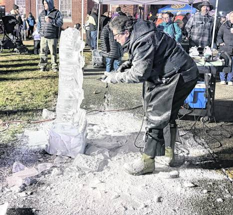 An ice sculptor creates a piece during the tree lighting.