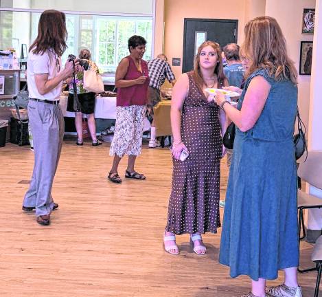 Guests and artists are shown at the exhibition.