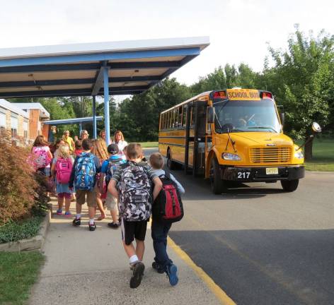 Just off the bus, kids line up to go into school for the first day.