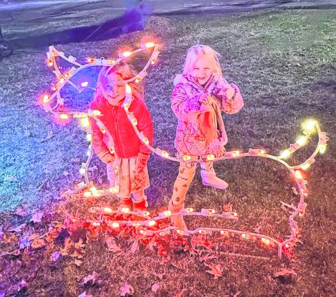 Odette Helmrich, 4 and Morgan Ruhl, 5, both of West Milford pose behind a light-up reindeer.
