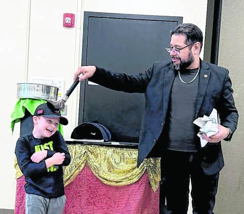 Jackson Bailey, 6, assists Mr. Magico.