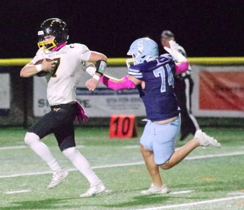 In the first half West Milford quarterback Aydin Deane is chased by Sparta defensive end Ryder Chlodnicki in the open field. Deane scored one rushing touchdown.