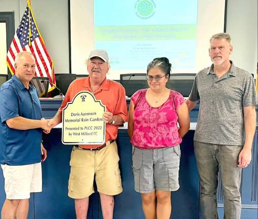 West Milford Environmental Commission Chairman Steve Sangle presents Pinecliff Lake Community Club representatives with a sign to be placed at the Doris Aaronson Memorial Rain Garden being constructed at the lake community clubhouse.