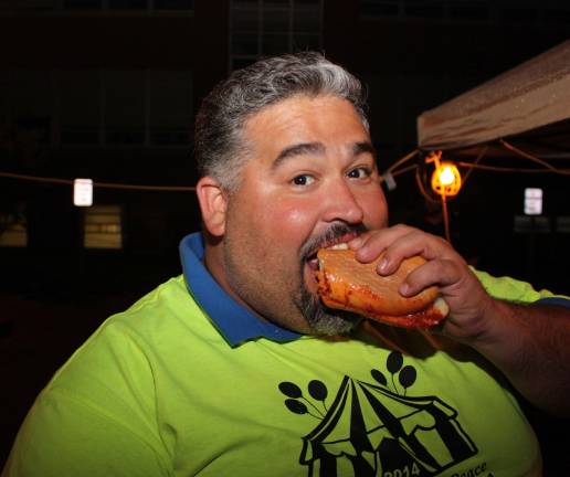 Volunteer worker Enrique Blanco takes time out to enjoy a meatball hero. Photo by Ginny Raue