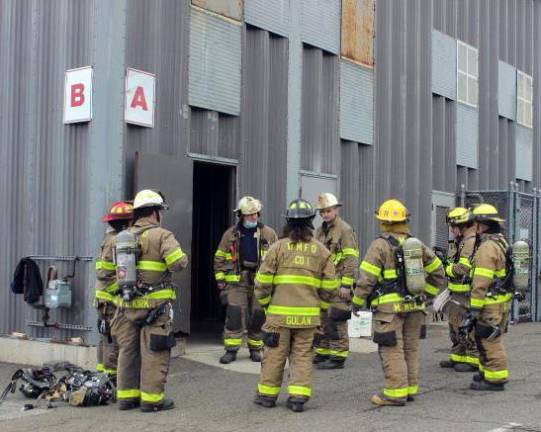 Firefighters from West Milford Company 1 and Company 6 discuss strategy during a training session at the indoor fire training center located at the Passaic County Public Safety Academy in Wayne, N.J.