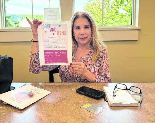 Maria Ojeda Pasterchick holds up a paper titled, Grief and Teens.