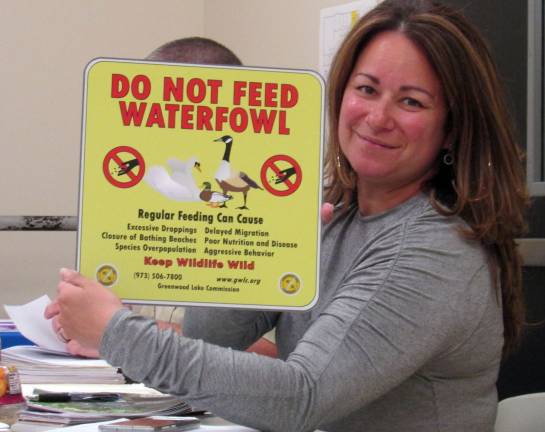 Greenwood Lake Commission Secretary Allison Wagner holds one of the signs that will be appearing around the Greenwood Lake area to address the geese problem. ANN GENADER photo