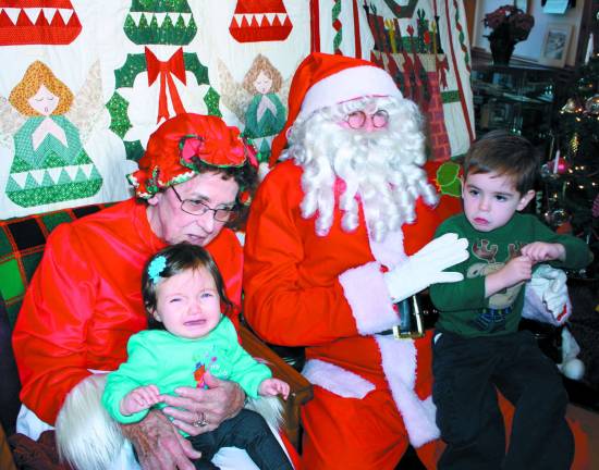 Photos by Ginny Raue Three year old Wyatt McLaud is pretty cool about his visit with Santa. Little sister, seven month old Lyla, is not so sure about it.