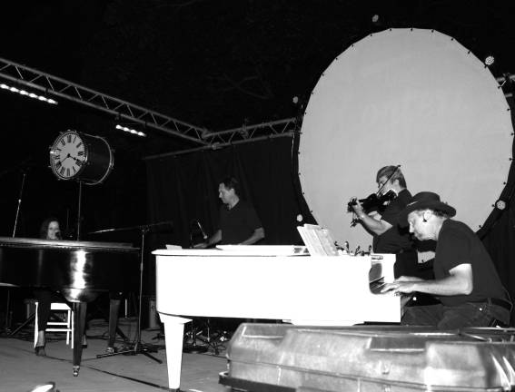 Seeing double. The beautiful music from two grand pianos, played by Jeni Li, left, and Morgan Paul, on far right, was joined by the melodious sounds from viloinist Ben Zabel and percussionist Michael Kulicke at the Concert for the Caring at Bubbling Springs Park on Thursday, 8/15/13. The original music and songs warmed the crowd on a cool August evening. Photo by Ginny Raue