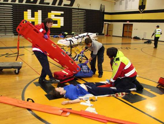 Photos by Ginny Raue West Milford First Aid Squad and Milton First Aid Squad EMTs tend to a "gunshot victim" at the Mass Casualty Incident drill at West Milford High School on Nov. 2. The drill, held to test the readiness of emergency crews in case of a catostropic incident, brought many emergency workers and vehicles from the town and from out of town. The "victims" were played by Girl Scouts, acting students from the school and the West Milford Players.