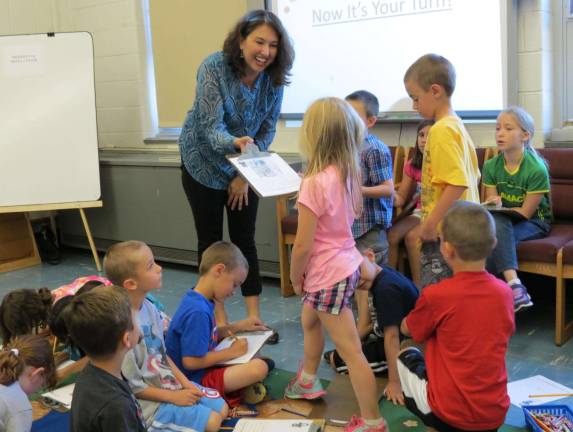 Mary L. Moore, author of Mommy Fit It Up, enjoys it when the children of Apshawa take their turn at writing a story.
