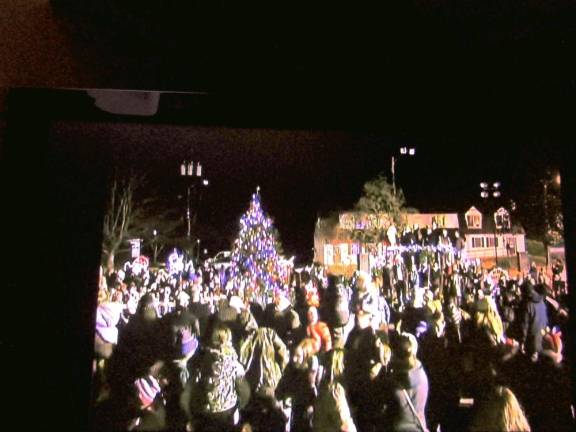 Residents gather at the decorated tree on the lawn of town hall.