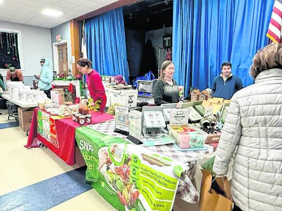 A customer peruses the tables at the West Milford Farmer’s Market.
