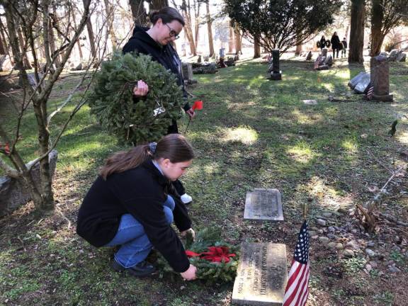Riley Casimiro, 16, of Mahwah places a wreath on a veteran’s grave as her mother, Kelly, watches Saturday, Dec. 16. After they heard about Wreaths Across America, they looked for an event near their home. They said they came to West Milford because they wanted to do their part and pay respect to the nation’s heroes. (Photos by Kathy Shwiff)