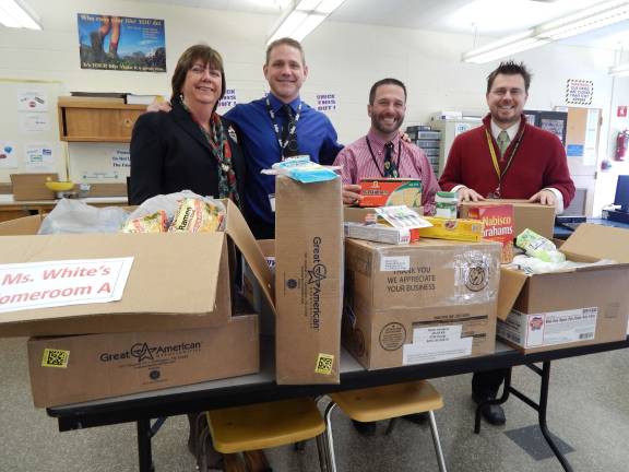 Macopin School Principal Mary Reinhold, Assistant Principal Marc Citro, Operation Thank You founder Richard Dygos and Art Joecks holding care packages and and standing next to even more! All were sent to U.S. Soldiers in Afghanistan.