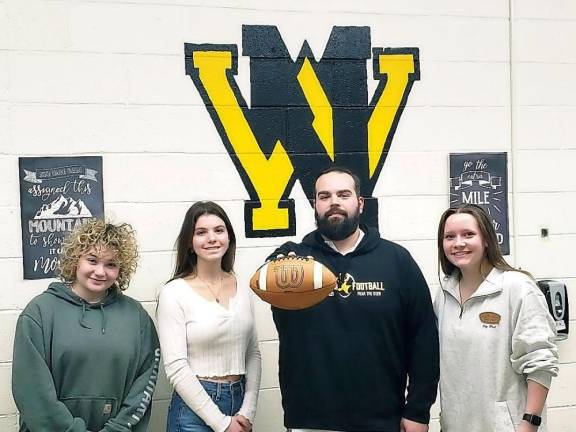 From left, senior Sarah Pilaar, junior Avery Vacca and senior Jakki Galella attended a sign-up meeting about the new girls flag football club with coach Matthew Keyzer. (Photo by Rich Adamonis)