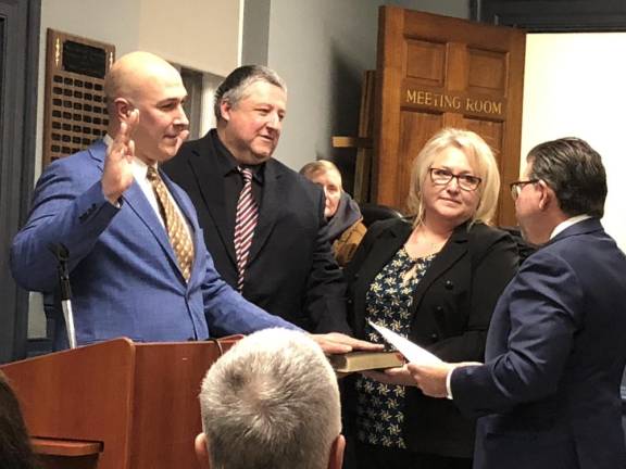 Councilmen Michael Chazukow, left, and David Marsden take the oath of office as Mayor Michele Dale holds the Bible and state Sen. Anthony Bucco, R-25, administers the oath.