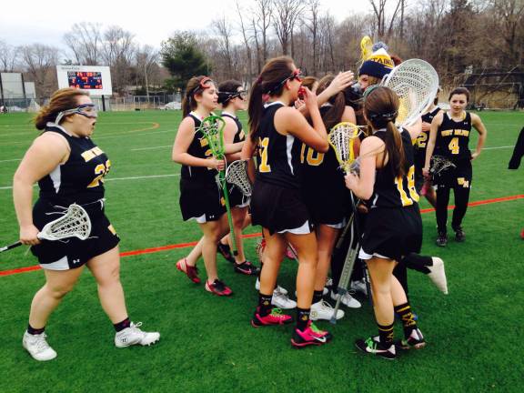 The junior varsity girls lacrosse team celebrates after a tough win against Pope John this season. They've yet to lose.
