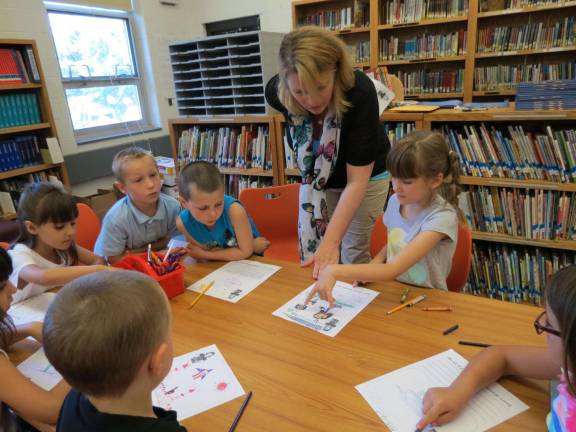 Illustrator Cheryl Crouthamel helps the students with their illustrations.