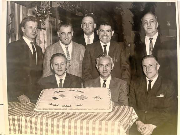 Members of the Italian American Club of West Milford at their first social function at the Beach Cliff Hotel in Upper Greenwood Lake in 1966. The cake has flags of the United States and Italy. Seated, from left, are Joseph Oddo, club president; Henry Cantaluppi; and Anthony Tucci. Standing, from left, are John Errico, James LaGreco, James Morreale, John Grecco and Frank Licursi. (File photo by Ann Genader)