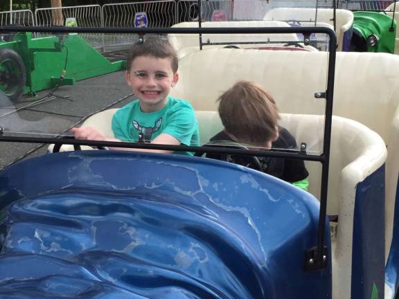 Photo provided Troy and Aaron Redner enjoyed the Queen of Peace Family Festval last weekend, May 14. The rides were fun but running around in the rain was the highlight of their day.